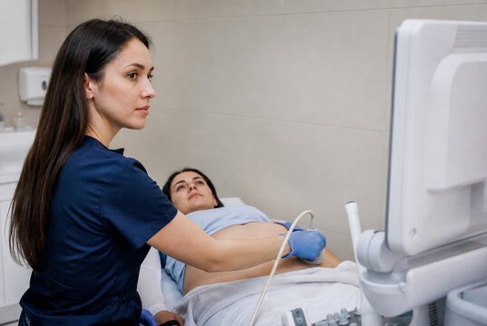 Ultrasound technician performing abdominal examination