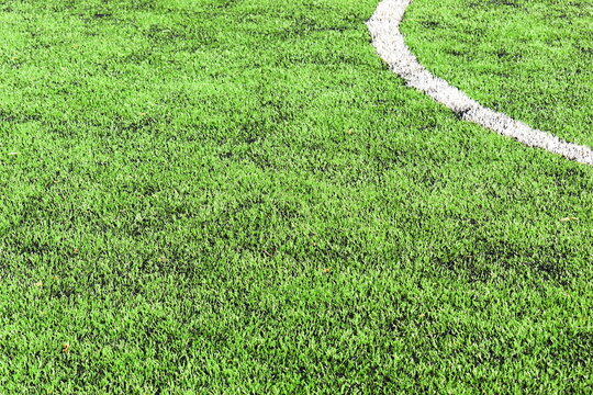 green synthetic grass field texture with white boundary line for sport background