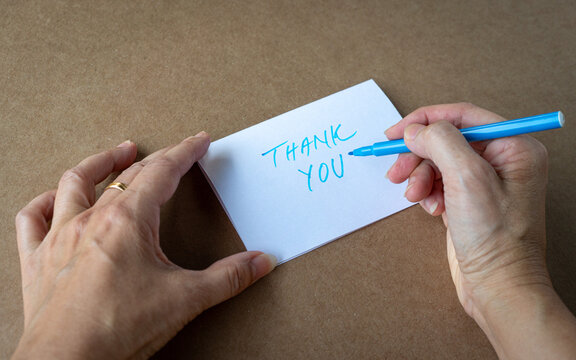 Female writing a thank you card - close up and top view.