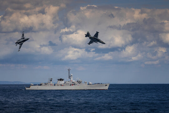 A military planes flies over a warship during a peacekeeping operation in the Black Sea.