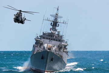 A helicopter flies near warship during a naval exercise in the Black Sea. © ValStock