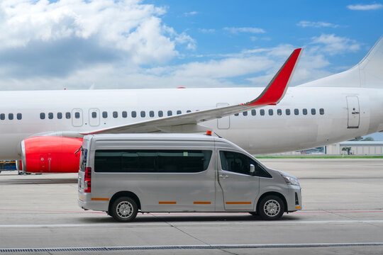Business class service at airport. Security intelligence agency hurrying at airfield. White vip service van running on airport taxiway with big passenger airplane.