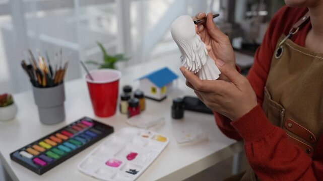 Female artist painting a 3d printed figurine. 3d printer