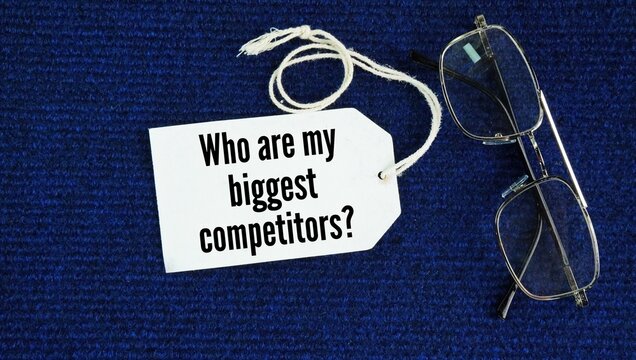 Tag paper with the words Who are my biggest competitors? rival businesses in a market or to a motivational idea about personal growth
