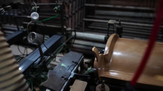 Two curved unfired roof tiles moving together along a factory finishing conveyor
