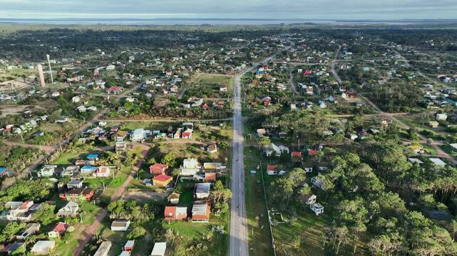 Punta del Diablo aerial town view with a central road extending toward the horizon, Departamento de Rocha, Uruguay
