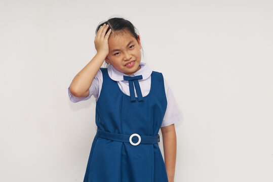 Confused Asian Schoolgirl in Blue Uniform Holding Head Isolated on White
