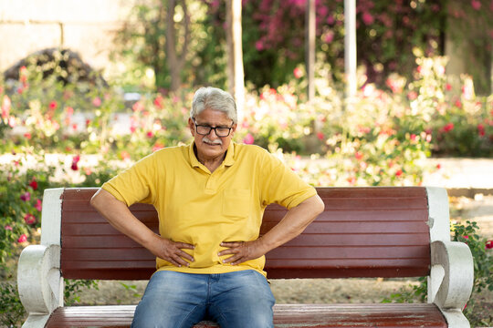 Painful senior old man suddenly suffering stomach pain at park