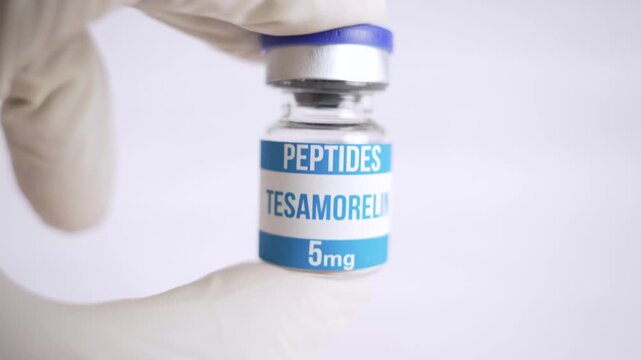 Scientist's hand in a glove holding a vial of tesamorelin peptide isolated on a white background