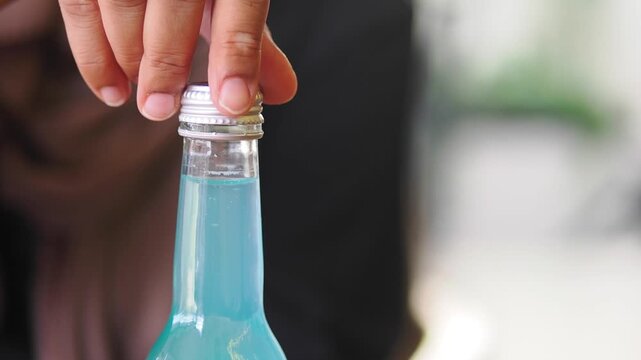 hand removing a bottle cap .