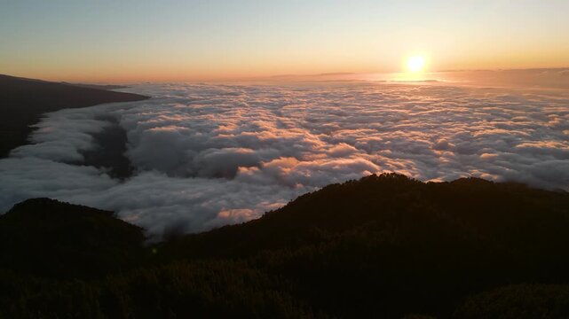 Sunrise over dense clouds and mountain ridges at a scenic Tenerife viewpoint