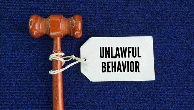 The judge gavel and tagged the paper with the words Unlawful behavior. any action or conduct that is not allowed by law.