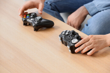 Gaming and social connection, friends playing video games together with controllers on a wooden table at home © Pixel-Shot
