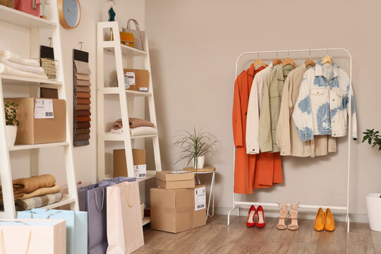 Interior of online store warehouse with clothes rack, shelf units and parcel boxes