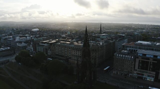 Aerial view of Edinburgh city center featuring Scott Monument and historic architecture under cloudy sky.