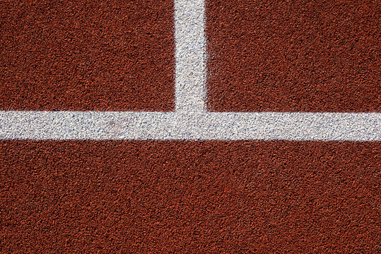 Running track surface texture with white line.