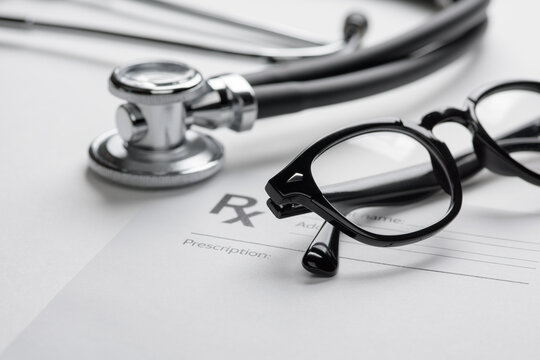 Stethoscope, glasses, and prescription pad for medical care.