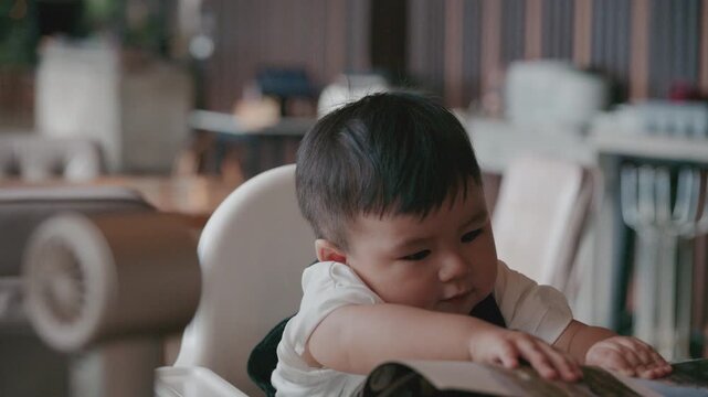 Asian baby boy self feeding sweet corn using baby led weaning method at home.	