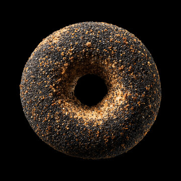 Closeup of a poppy seed covered bagel isolated on a black background with clipping path, representing fresh bakery food