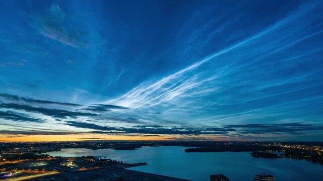 Stunning timelapse footage of noctilucent clouds moving over water at sunset.