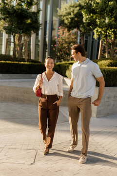 Couple enjoying a sunny day while strolling through a modern city park