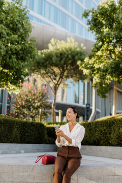 Korean woman enjoying a sunny afternoon in a modern urban park