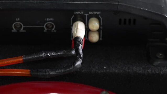 Audio RCA cables with electrical tape connected to car amplifier.