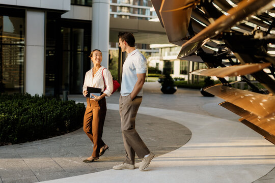 Enjoying a warm conversation in a modern urban setting on a sunny day