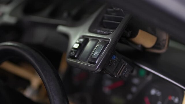 Car dashboard trim panel with air vent removed for repair.