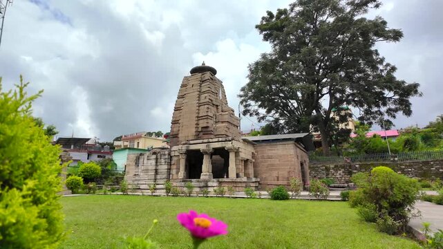 Historic Mrityunjay Temple Framed by Green Garden in Dwarahat, Uttarakhand