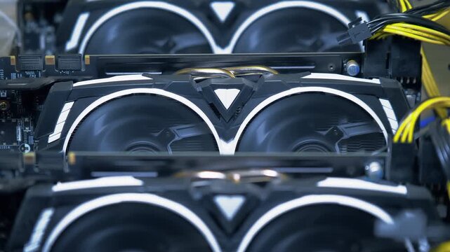 Centered rows of active graphics cards form a repeating pattern of spinning dual fans with PCIe power connections visible inside an open frame GPU mining rig