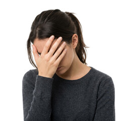Fototapeta premium A young woman holds her hand over her face, showing distress and sadness.