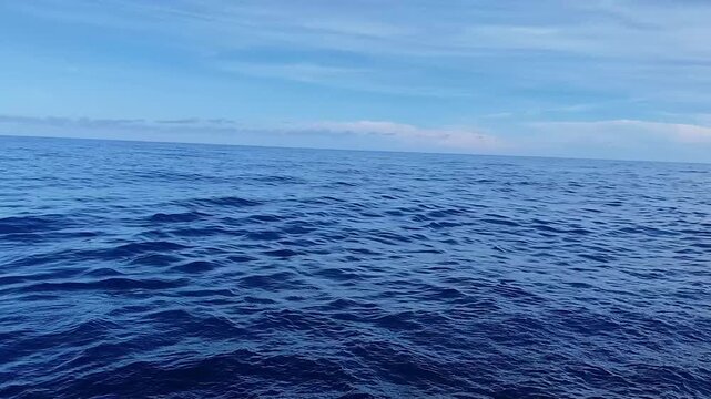 Deep blue ocean waves rolling under a vast sky footage motion
