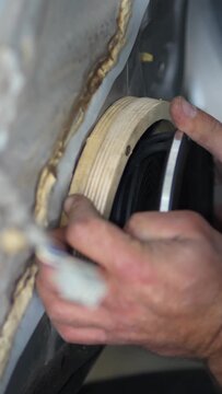 Man hands fitting acoustic speaker into custom plywood adapter ring.