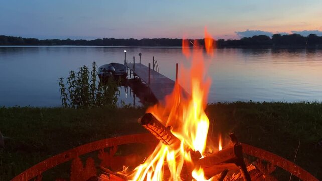 Handheld close-up shot of a small fire pit at a cabin on a lake in Minnesota. 4K
