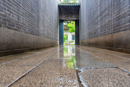 Wet Stone Alley with Brick Walls and Water Reflection