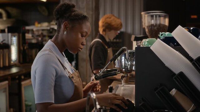 Young adult African American female barista purging steam wand and cleaning espresso machine behind cafe counter. Perfect for coffee shop branding, cafe promotions, and hospitality ads
