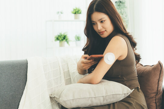 Woman Checking Blood Glucose Level During Telehealth Consultation at Home