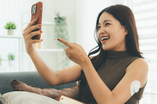 Woman Checking Blood Glucose Level During Telehealth Consultation at Home