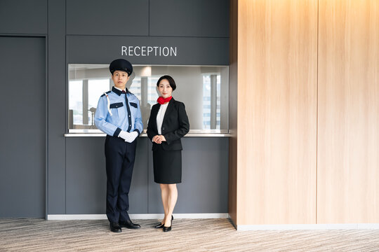 受付に立つ警備員とスタッフ。ホテル、ホテリエ、警備、セキュリティ、防犯、安全、仕事、施設、案内、企業