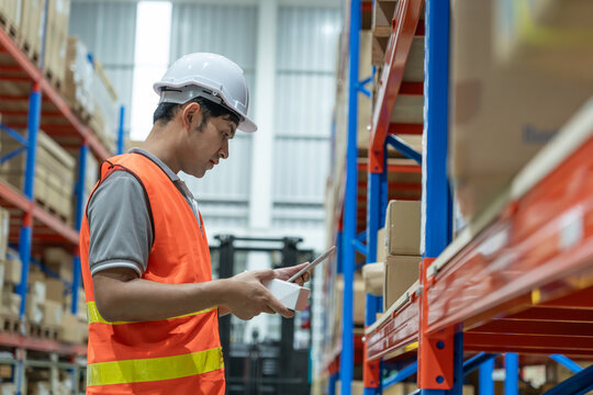 Warehouse worker pick box goods in inventory and check stock product. Transport logistic business ship delivery to customer. stock card, bill of material, inspection, storehouse, storage, factory