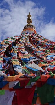 The Changqing Chunker Temple in Litang, China. Many colourful prayer flags on the mountain top beside the temple.Spirituality and meditation.	