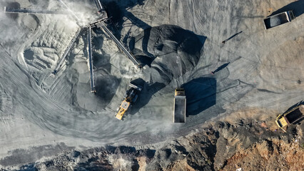 Heavy machinery loads coal onto dump trucks at an industrial open pit mining site in Indonesia © A Denny Syahputra