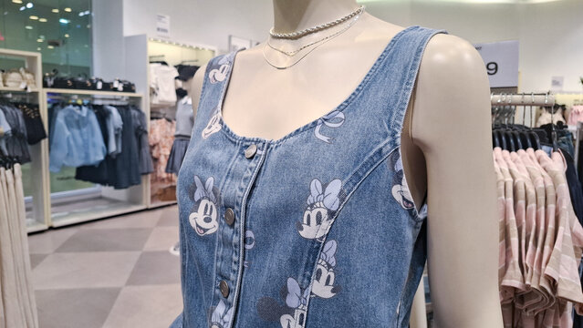 Close up view of mannequin wearing HM Disney Minnie Mouse denim overall dress on display in retail store
on August 20, 2026 in Bangkok, Thailand