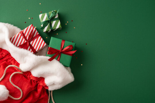 Merry Christmas and Happy New Year with Santa Claus presents spilling from a red velvet sack on green banner background