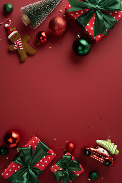 Merry Christmas flatlay with wrapped gifts and ornaments for a Happy New Year celebration on burgundy vertical background