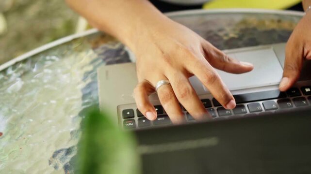 Person's hands typing on laptop keyboard