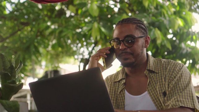 African american entrepreneur talking on phone at cafe