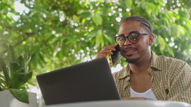 African american entrepreneur talking on phone while working remotely