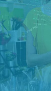 Animation of multiple graphs, trading boards, midsection of caucasian woman using credit card reader